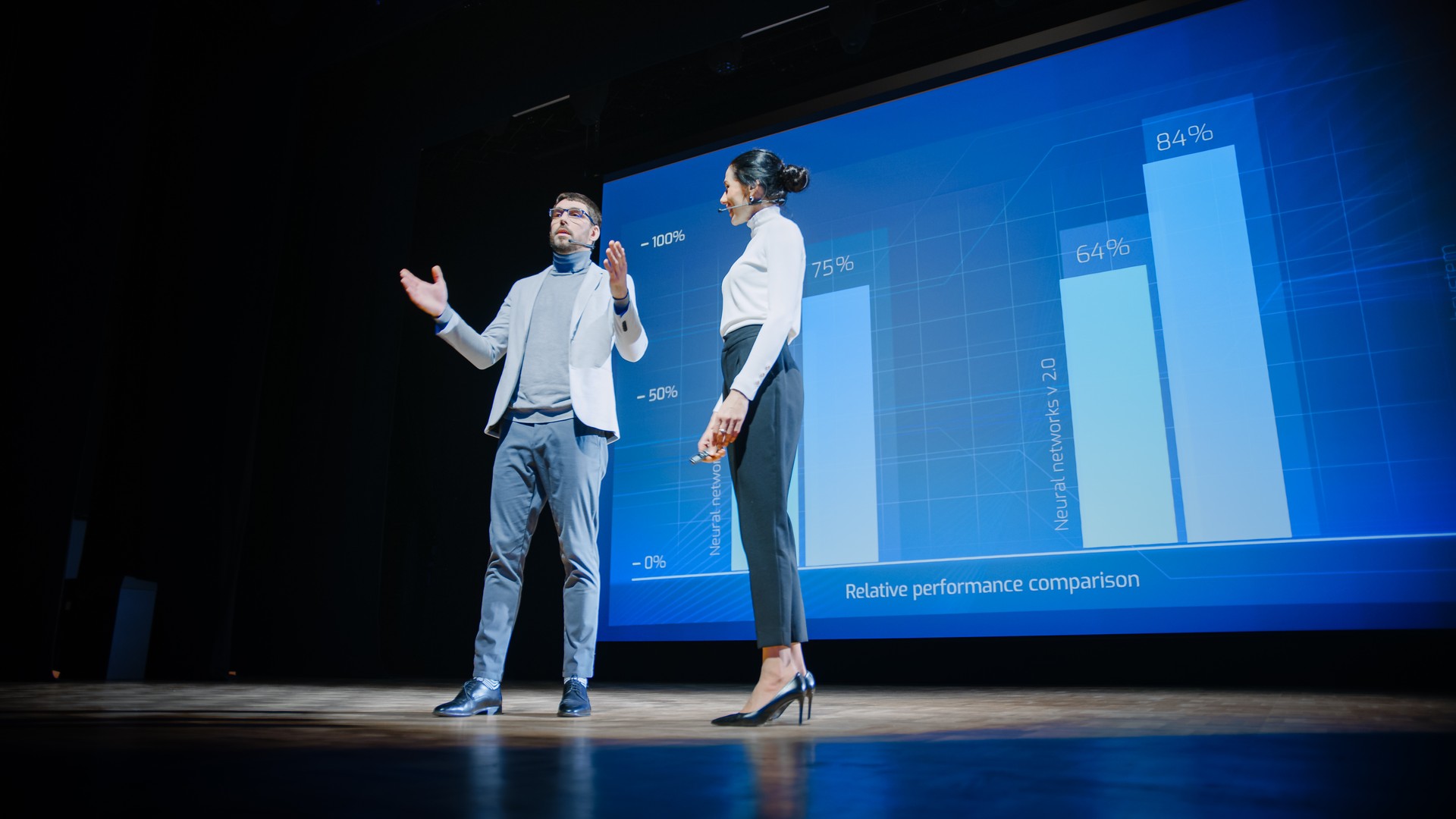 Sur scène, les femmes pdg et les haut-parleurs de coo masculins présents nouveau produit de la société, montrent infographies, statistiques sur grand écran, parler de croissance. Live Event, Tech Startup, Business Conference